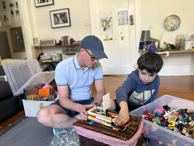 Max playing LEGO with a child